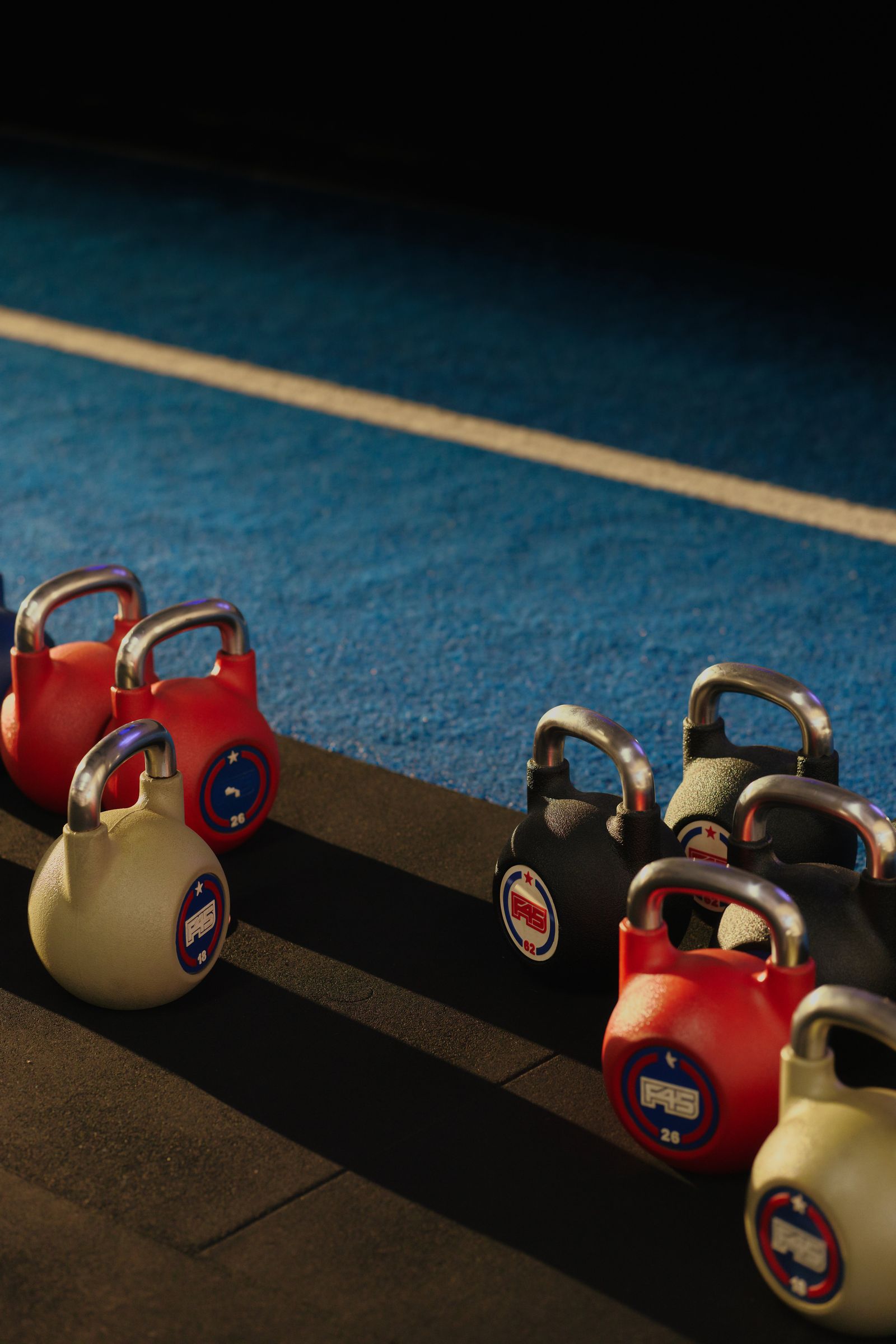 Kettlebells on blue turf in a fitness studio